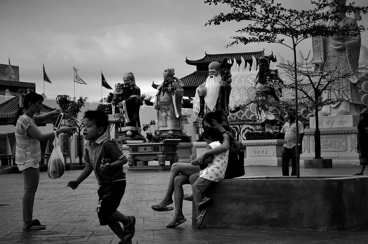 men, large group of people, person, walking, street, lifestyles, full length, leisure activity, tree, building exterior, city, built structure, mixed age range, road, city life, architecture, sky, togetherness, casual clothing