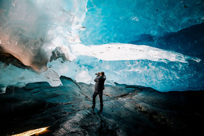 Full length of man standing on frozen sea during winter