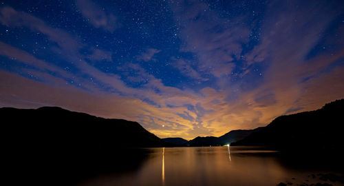 Scenic view of silhouette mountains against sky at night
