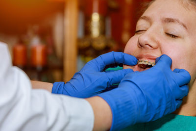 Cropped hands of dentist examining patient