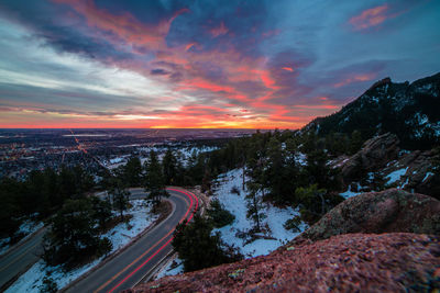 Scenic view of road by mountains against sky during sunset