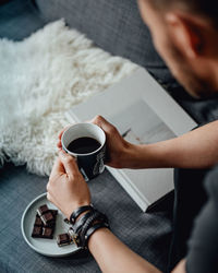 Midsection of man holding coffee cup