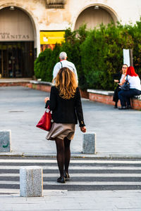 Rear view of women walking in city