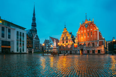 Illuminated buildings in city at dusk