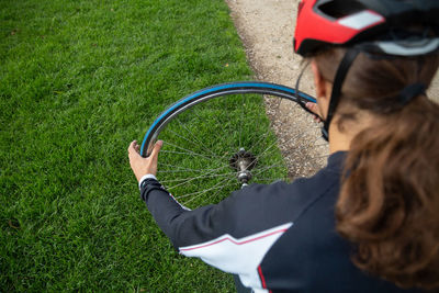 High angle view of woman holding bicycle on field