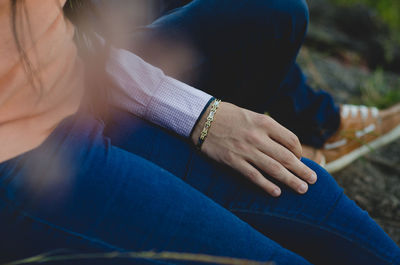 Midsection of couple sitting outdoors