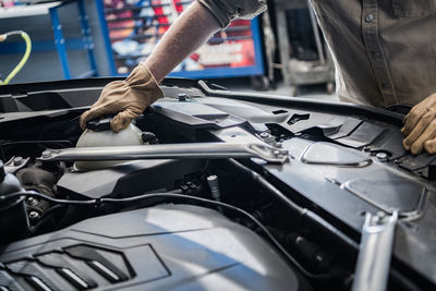 Midsection of man repairing car