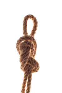Close-up of rope tied to metal against white background