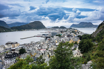 High angle view of town by sea against sky