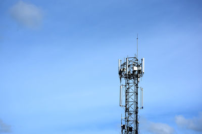 Low angle view of communications tower against blue sky