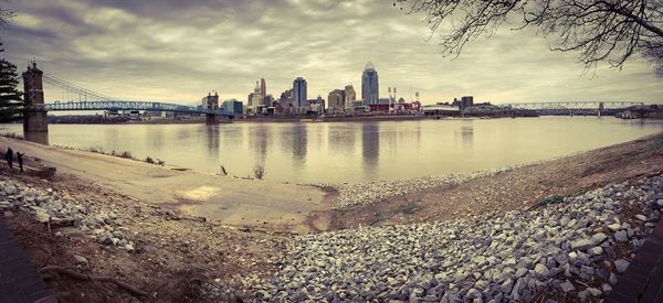 View of city by river against sky