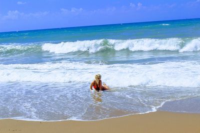 Woman in sea against sky