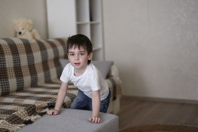 Toddler child sad on the couch in the real room at home, lifestyles and toning