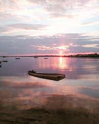 Boat in sea against sky during sunset