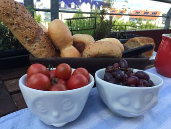 Close-up of tomatoes and grapes with bread on outdoor table