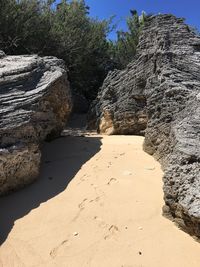 Rock formation on beach against sky