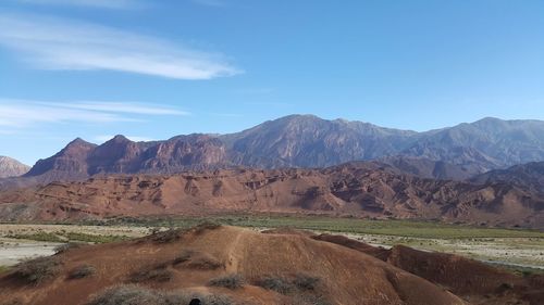 Scenic view of mountains against blue sky