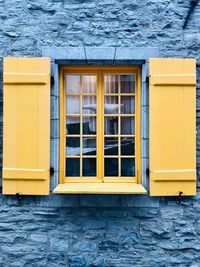 Close-up of yellow windows on wall of building