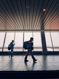 Rear view of men walking in airport