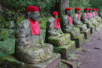 Old mossy statues in row at forest