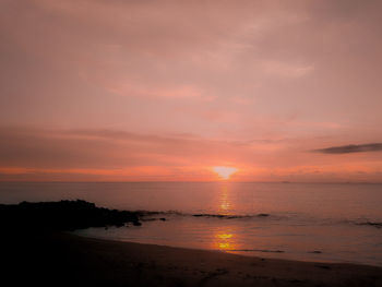 Scenic view of sea against romantic sky at sunset