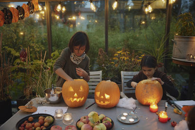 Girls carving pumpkins in greenhouse