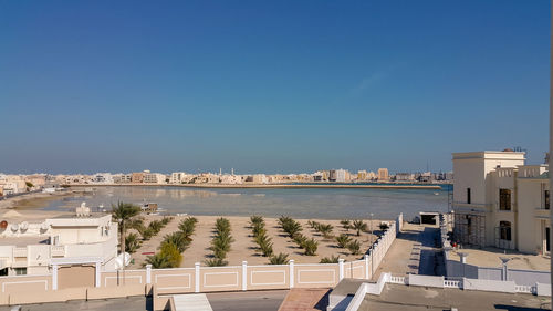 High angle view of buildings and sea against clear sky