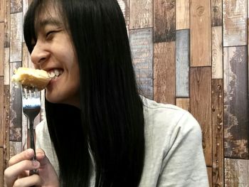 Portrait of smiling young woman eating food
