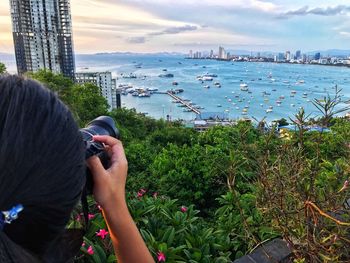 Rear view of woman photographing sea against sky