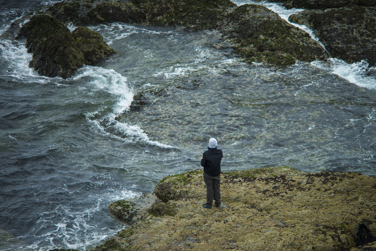 rock - object, one person, rear view, full length, nature, standing, adventure, high angle view, river, outdoors, beauty in nature, day, water, one man only, leisure activity, vacations, real people, waterfall, mountain, men, scenics, adult, people, power in nature, climbing, adults only, only men