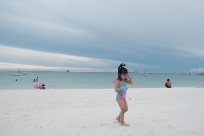 Full length of woman on beach against sky