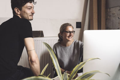 Smiling computer programmer with coworker at workplace