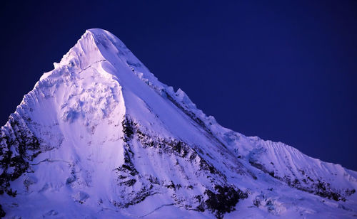 Snow covered mountain against blue sky