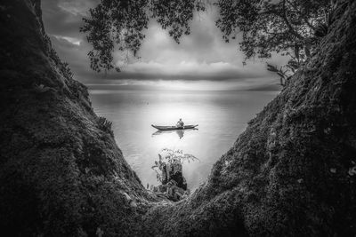 High angle view of man on boat sailing in sea against cloudy sky