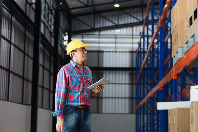 Man working with umbrella standing in building