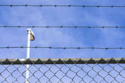 Low angle view of barbed wire against sky