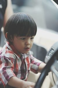 Close-up of cute boy sitting in car