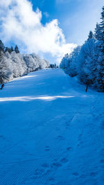 Scenic view of snow covered mountains against blue sky