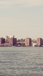 Sea in front of buildings against sky