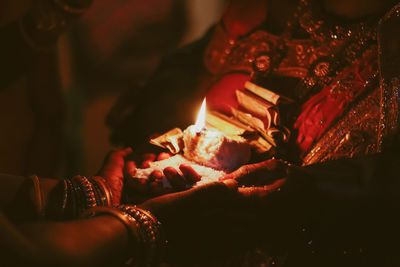Close-up of hand holding burning candle