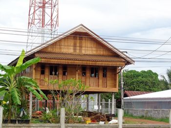 House by tree against sky