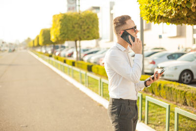 Man using mobile phone while standing on road