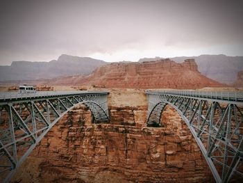 Arch bridge against cloudy sky