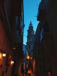 Low angle view of illuminated buildings against sky at night