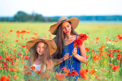 Young woman standing amidst flowering plants on field