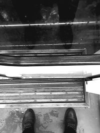 Low section of person standing on tiled floor