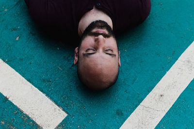 High angle view of man sleeping on road