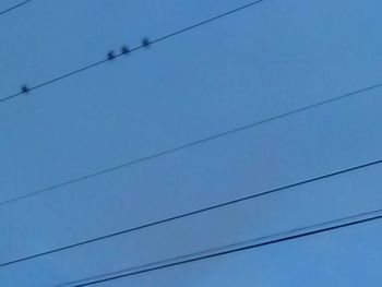 Low angle view of cables against blue sky