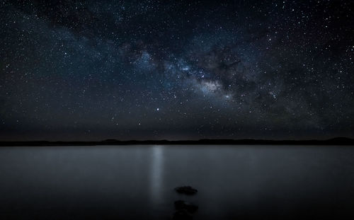 Scenic view of lake against sky at night