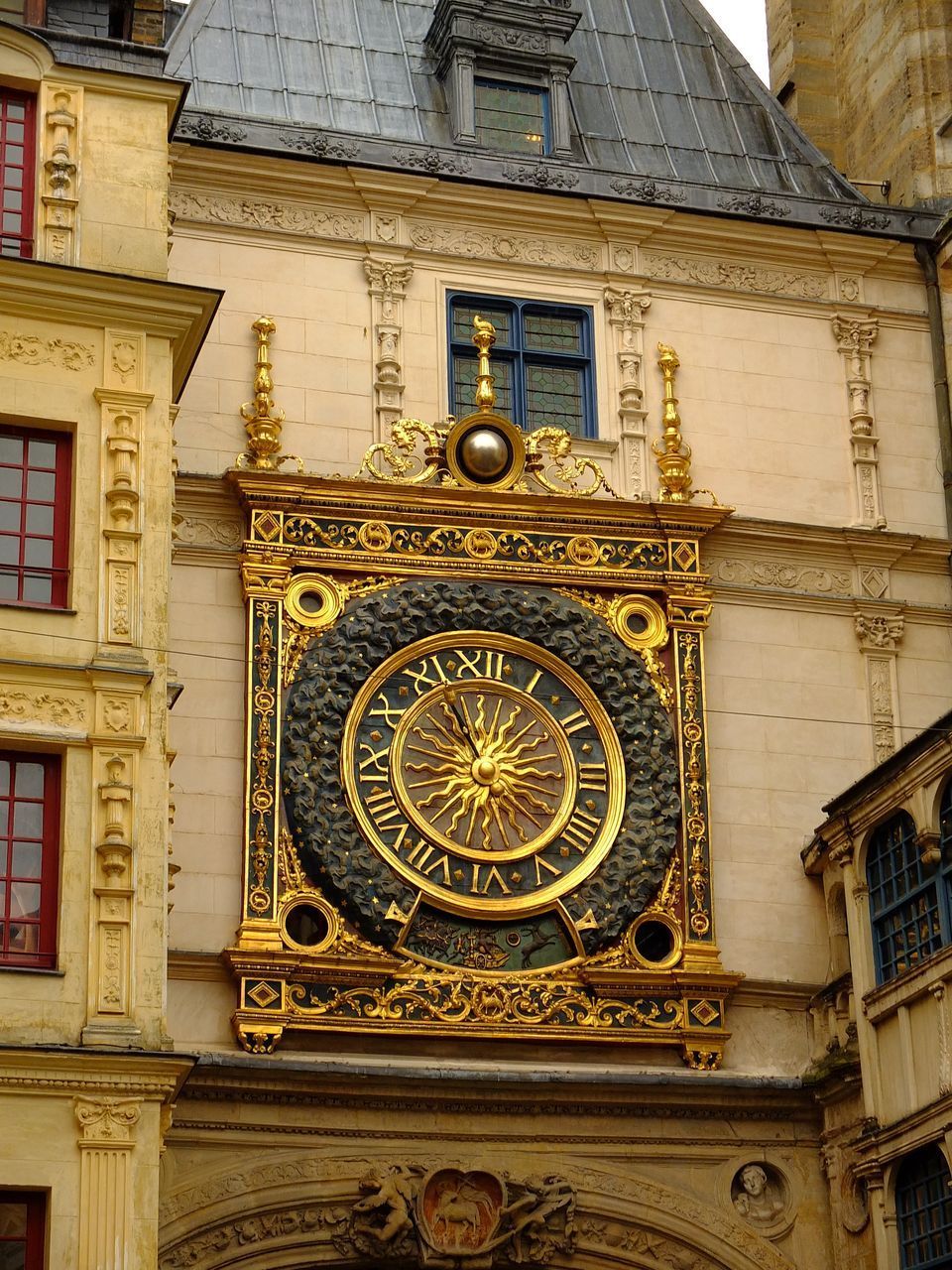 LOW ANGLE VIEW OF CLOCK TOWER AGAINST BUILDINGS